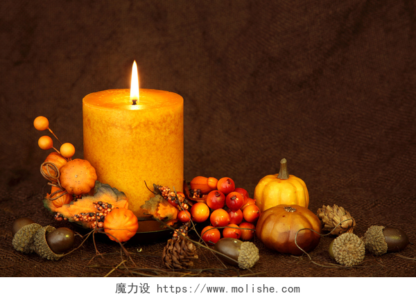 棕色的背景下点燃的蜡烛秋季蜡烛